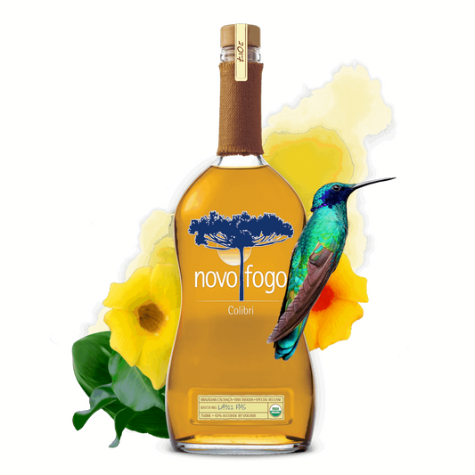Bottle of Novo Fogo Colada with a hummingbird and yellow flowers on a green background